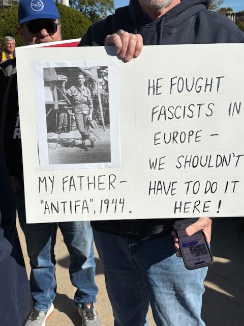 A handmade sign with a picture of a solder in WWII labeled "My father --"ANTIFA," 1944" To the right it says, "HE FOUGHT FASCISTS IN EUROPE -- WE SHOULDN'T HAVE TO DO IT HERE!"