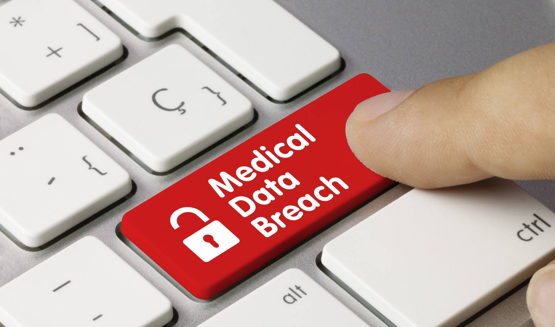 red key on a keyboard shows an unlocked lock and says "Medical Data Breach"